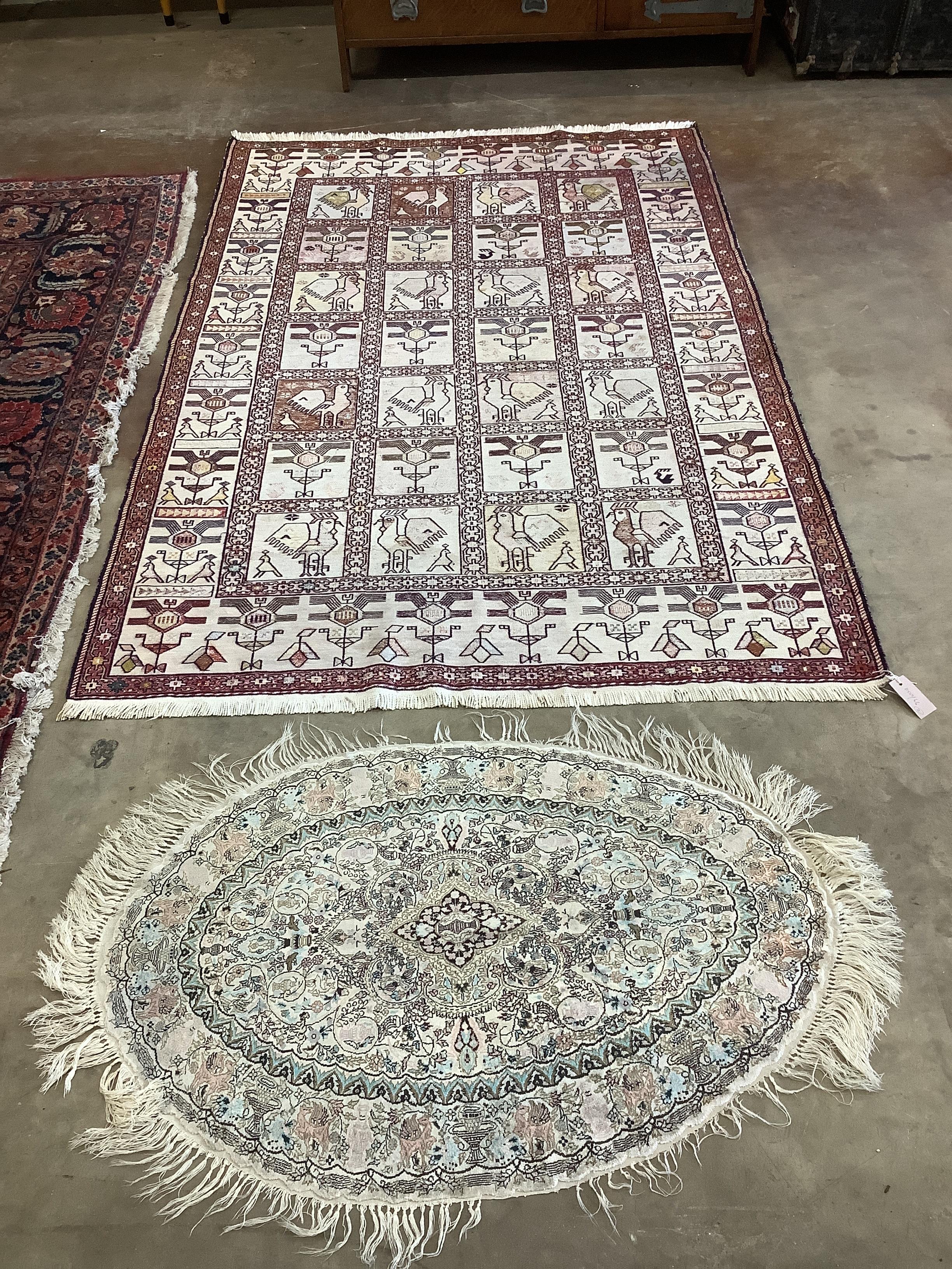 A Turkish Kilim flatweave rug, the ivory ground having geometric design panel, together with a small oval Chinese silk rug, larger 190 x 126cm